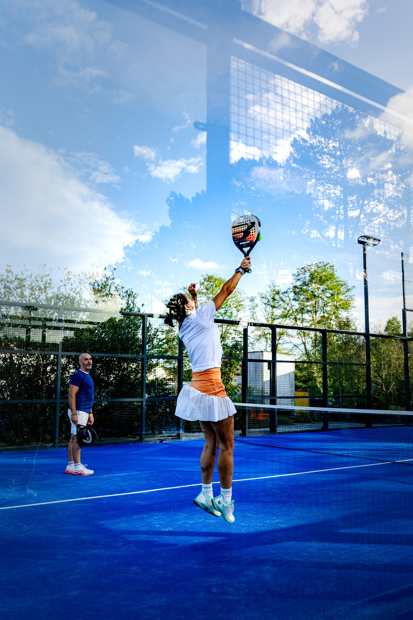 Joueuse de padel au smash sur un terrain du Punto
