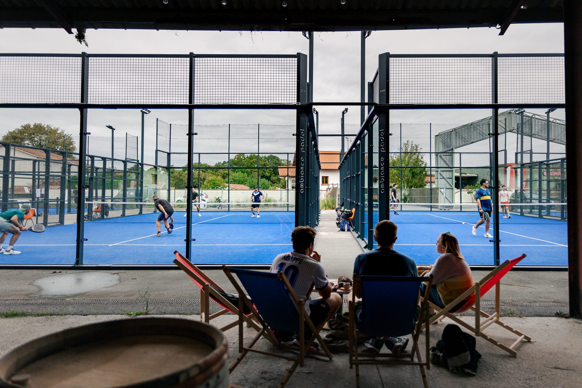 Spectateurs dans les transats face aux terrains de padel du Punto